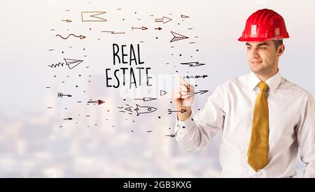 Junge Geschäftsmann mit Helm Zeichnung Verkauf Zeichen Stockfoto