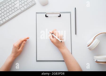 Frau schreibt auf leere Liste im Notizblock, um Liste zu tun. Weibliche Hände zeichnen am Büroarbeitsplatz auf einem Papiertablett. Weibliche Hand schreiben im Notizbuch bei Stockfoto