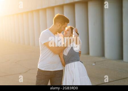 Mittellange Aufnahme Porträt eines romantischen jungen Paares in der Liebe umarmen, während Mann den Hals der Freundinnen mit der Hand berühren. Stockfoto