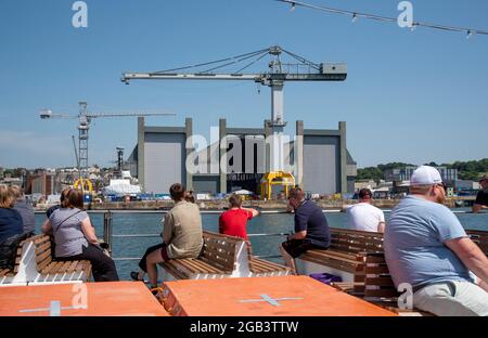 Plymouth, Devon, England, Großbritannien. 2021. Passagiere, die die Werften der Royal Navy von einer Kreuzfahrt entlang des Flusses Tamar, Plymouth, Großbritannien, betrachten Stockfoto