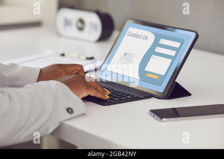 Kunde, der ein Tablet verwendet und eine E-Mail in das Kontaktformular auf der Landing Page oder Website schreibt Stockfoto