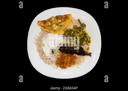 Kerala-Mittagessen Mit Matta-Reis Oder Kuthari Choru, Omelett, Fischfry, Chutney Und Gemüse. Isolierter Schwarzer Hintergrund Stockfoto
