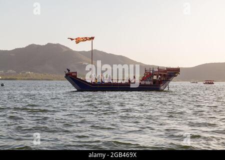 UDAIPUR, INDIEN - 20. MÄRZ 2016: Ein Boot und Menschen auf dem Lake Pichola in Udaipur während des Tages. Stockfoto