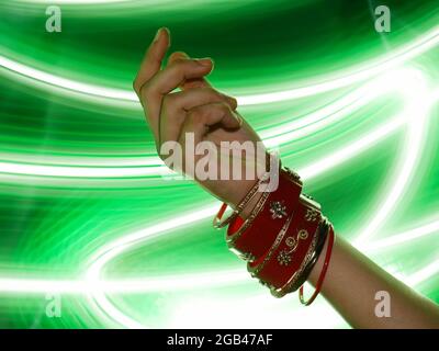 Indische Stil Bangles präsentiert auf Mädchen Hand mit Lichteffekt Glanz Hintergrund, kommerzielle Mode Produkt Präsentation Bild. Stockfoto