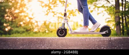 Frau Reiten auf Roller im Park im Sommer Stockfoto