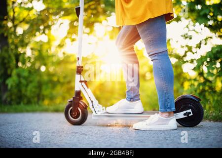 Frau Reiten auf Roller im Park im Sommer Stockfoto