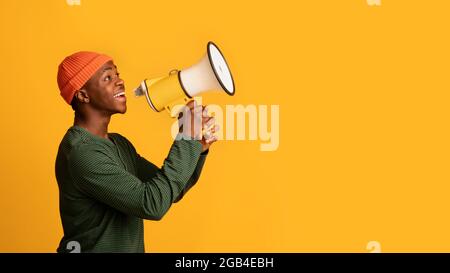 Portrait Des Schwarzen Hipster Guy Mit Megaphon In Den Händen, Der Ankündigung Macht Stockfoto