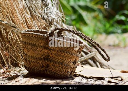 Handgemachte Datteln Baumkasten Werkzeug, Palmblatt trocken Glas hängen auf Holz im Garten, braun Hintergrund Kultur Ding Foto Stockfoto