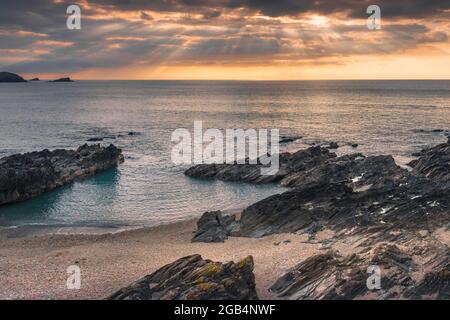 Ein spektakulärer Sonnenuntergang über der Fistral Bay von Little Fistral in Newquay in Cornwall. Stockfoto