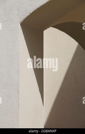 Abstrakte Bogenlinien. Kunst- und Designkonzept. Schattenstruktur. Platz für Text. Licht und Schatten an der grauen Wand. Stockfoto