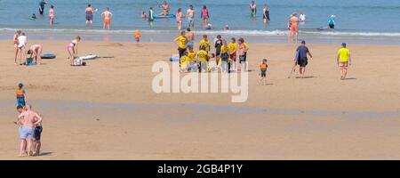 Ein Panoramabild einer Gruppe von Menschen auf einem Beach Lifeguard Kurs am Fistral Beach in Newquay Cornwall. Stockfoto