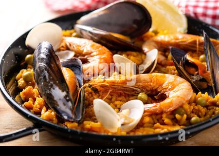 Traditionelle spanische Paella mit Meeresfrüchten auf einem Holztisch Stockfoto