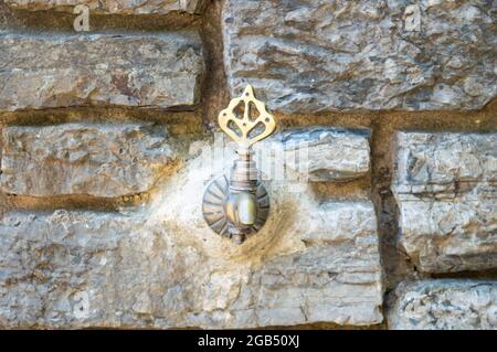 Antike Wasserhahn auf alten Steinwand Textur abstrakten Hintergrund.Historische Brunnen, antike türkische Wasserhahn an der Wand Stockfoto