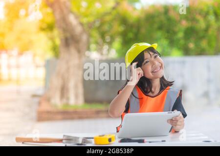 Asiatische Mädchen Kinder spielen als Ingenieur Helm lächeln und glücklich an den Wochenenden. Stockfoto