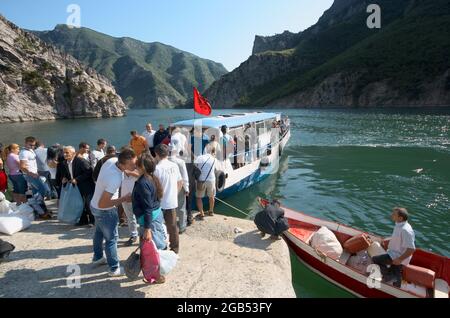 Menschen und Touristen im Norden Albaniens See Koman Andocken der Fähre Boot für die Abholung von Passagieren von Fierze nach Koman und zurück - August, 2012 Stockfoto