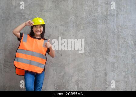 Asian Kid Mädchen trägt reflektierende Hemden und einen Hut gelb. Zum Lernen und zur Verbesserung der Entwicklung, kleiner Architekt. Stockfoto