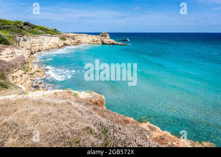 Der Punticeddha Strand oder Spiaggia Punticeddha von Sant'Andrea, Adriaküste Salento, Apulien, Italien. Schöne sandige Küste von Apulien mit blauem Wasser, Klippen an einem Sommertag, Blick von oben Stockfoto