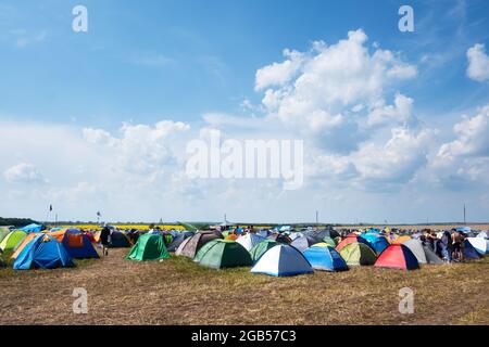 Zelte auf einem Campingplatz für Musikfestivals. Blauer Himmel mit Wolken im Hintergrund Stockfoto