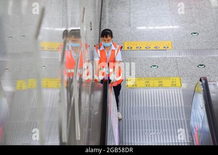 (210802) -- CHANGSHA, 2. August 2021 (Xinhua) -- EIN Mitarbeiter desinfiziert einen Handlauf einer Rolltreppe an der Machang U-Bahnstation in Changsha, der zentralchinesischen Provinz Hunan, 2. August 2021. Um das jüngste Wiederaufleben von COVID-19 einzudämmen, hat die Changsha Metro Group die Maßnahmen zur Prävention und Kontrolle von Epidemien verstärkt, um den Passagieren eine sichere Reise zu ermöglichen, indem die Desinfektionshäufigkeit öffentlicher Kontakteinrichtungen erhöht und strengere Maßnahmen zur Bekämpfung von Epidemien wie Maskenverschleiß, Temperaturmessung und Überprüfung des Gesundheitscodes eingeführt werden. Isolationsbereiche sind für Menschen mit hoher Körpertemperatur eingestellt Stockfoto