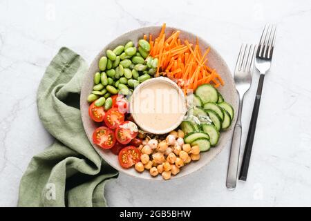 Veganer Buddha Bowl Salat Mit Kichererbsen, Gemüse, Edamame-Bohnen Und Cashew-Sauce Stockfoto