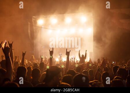 Silhouetten von Konzertbesuchern vor hellen Bühnenlichtern. Rock- und Metal-Musikkonzept Stockfoto