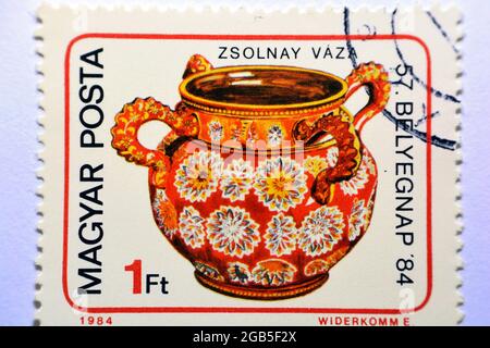 Eine in Ungarn gedruckte Briefmarke zeigt eine vierhandige Vase, Zsolnay, um 1984, Alte Briefmarke zeigt eine Vase aus der Porzellanfabrik Zsolnay, rot 1984, Stockfoto