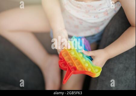 Kind spielen mit sensorischen Spielzeug. popit Makro Nahaufnahme Stockfoto