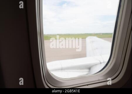 Flügel eines Flugzeugs im Aluminiumfenster. Stockfoto
