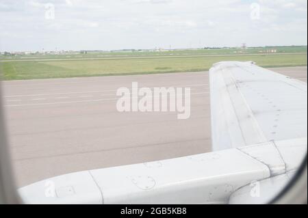 Flügel eines Flugzeugs im Aluminiumfenster. Stockfoto