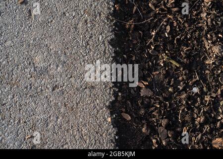 Draufsicht auf einen Boden und Asphalt, der die Trennung von Straße und natürlichem Boden zeigt Stockfoto