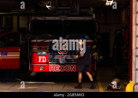 Feuerwehrmann geht vor den Feuerwehrautos in der Garage von FDNY Ladder 3 NYC Stockfoto