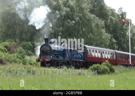 Blaue Dampflokomotive, die auf der Strathspey-Bahn durch die Landschaft dampft Stockfoto