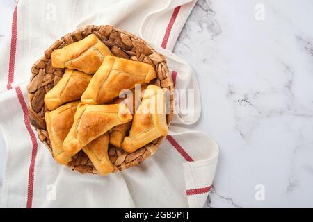 Gebratene Empanadas mit Koriander, Fleisch, Ei, Tomaten und Chilisauce auf weißem Hintergrund. Konzept des lateinamerikanischen und chilenischen Unabhängigkeitstages. Stockfoto