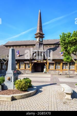 Der Marechal Foch-Platz in Etretat, Frankreich, mit dem Alten Markt, einer überdachten Markthalle aus dem Jahr 1927, und einem Obelisk-förmigen Brunnen an einem sonnigen Morgen. Stockfoto