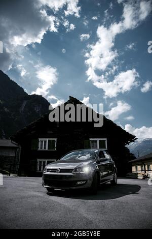 FAIDO, SCHWEIZ - 11. Jun 2021: Eine vertikale Aufnahme der Vorderansicht eines Autos, das Volkswagen vor einem Haus parkte Stockfoto