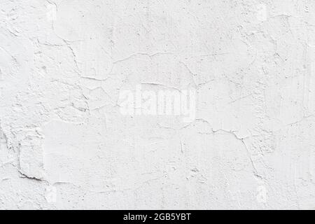 Textur der weiß lackierten Wand, abgeplatzt, Kratzer. Stuckwand aus nächster Nähe Stockfoto
