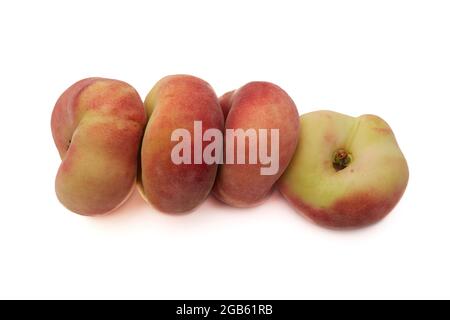 Ein Haufen von ganzen flachen Pfirsichen, die in einer Reihe aneinander gestapelt sind, isoliert auf weißem Hintergrund. Als Designelement. Stockfoto