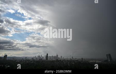 02. August 2021, Hessen, Frankfurt/Main: Während die Wolkendecke aus dem Westen bricht, zieht eine Regenfront über das Frankfurter Stadtgebiet mit seinen markanten Wolkenkratzern. Foto: Arne Dedert/dpa Stockfoto