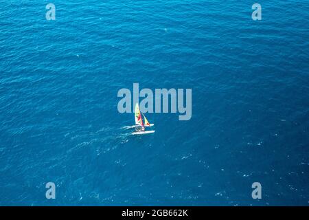 Luftaufnahme eines tragbaren Segelbootskatamarans im blauen Wasser der Adria Stockfoto