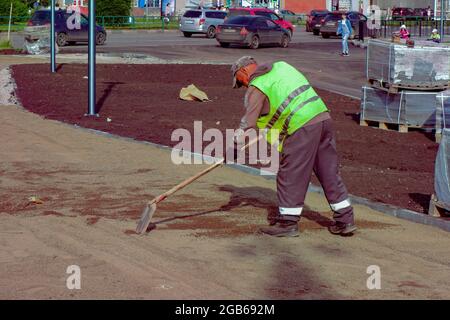 Ein Straßenarbeiter bereitet das Fundament für die Verlegung von Pflasterplatten vor. Stockfoto