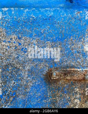 Struktur aus schäbig blau lackiertem Eisen Wand mit Rissen und Korrosion und Metall Detail Stockfoto