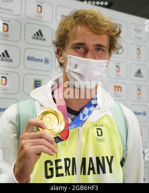 02. August 2021, Hessen, Frankfurt/Main: Der deutsche Tennisspieler Alexander Zverev zeigt seine Medaille auf dem Frankfurter Flughafen nach seiner Ankunft aus Tokio. Er hatte bei den Olympischen Spielen die Goldmedaille in den Herreneinzel gewonnen. Foto: Frank Rumpenhorst/dpa Stockfoto