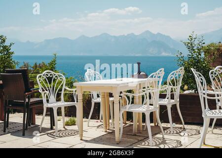 Ein Tisch in einem Restaurant oder einem Sommercafe an der Küste von Antalya, Türkei. Platz in einem Restaurant mit wunderbarem Meerblick. Hochwertige Fotos Stockfoto