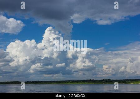 Mächtige Wolken über dem Bett eines großen Flusses mitten im Sommer Stockfoto