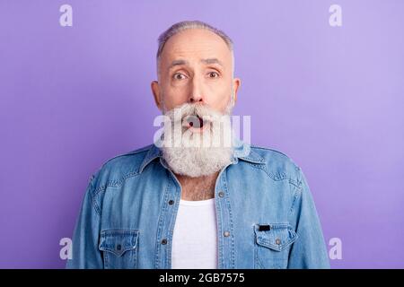 Foto von schweren schockiert Alter Gentleman tragen Jeans Hemd offenen Mund große Augen isoliert violette Farbe Hintergrund Stockfoto