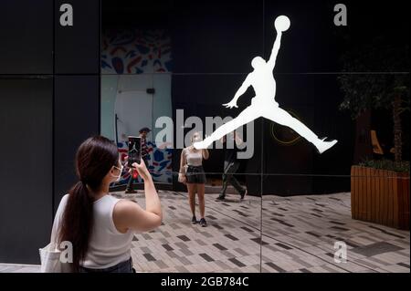 Hongkong, China. Juli 2021. Eine Frau macht ein Foto der amerikanischen Sportwear-Marke, produziert von Nike, Air Jordan, Logo in Hongkong. (Bild: © Budrul Chukrut/SOPA Images via ZUMA Press Wire) Stockfoto