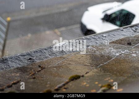 Verstopfte Rinne, gefüllt mit Wasser, das bei regnerischem Wetter überfließt. Stockfoto