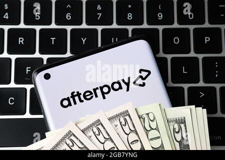 AfterPay-Firmenlogo auf dem Smartphone mit Dollar bedeckt und auf der Tastatur platziert gesehen. Jetzt kaufen später zahlen Unternehmen. Stafford, Großbritannien, 2. August 2 Stockfoto