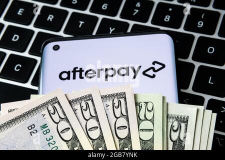 AfterPay-Firmenlogo auf dem Smartphone mit Dollar bedeckt und auf der Tastatur platziert gesehen. Jetzt kaufen später zahlen Unternehmen. Stafford, Großbritannien, 2. August 2 Stockfoto