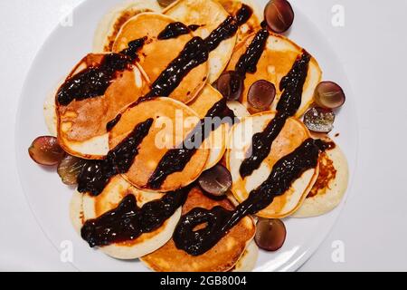 Hausgemachte glutenfreie Pfannkuchen mit Schokoladensauce auf einem weißen Teller. Stockfoto